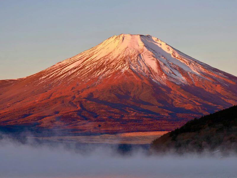 晨光中染紅的富士山和湖面霧氣